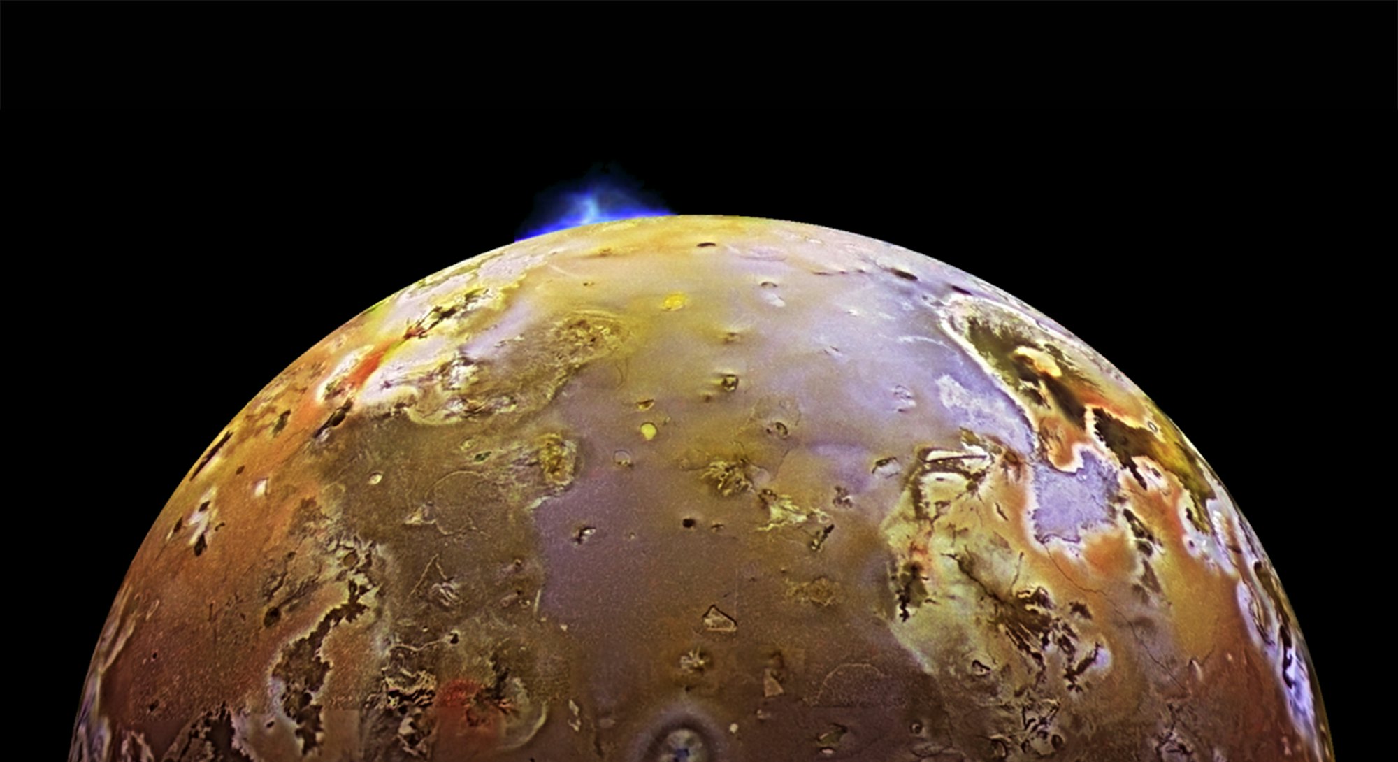 Voyager mission image of a volcanic eruption on Io, characterized by a bluish stream of light protru...