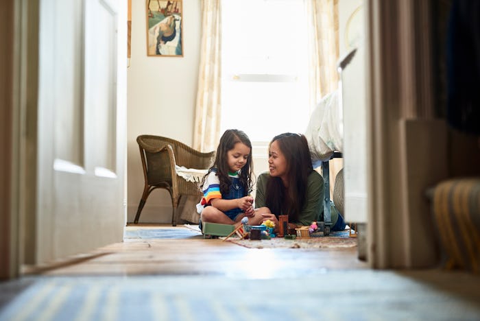 Mother and daughter play together on the floor.