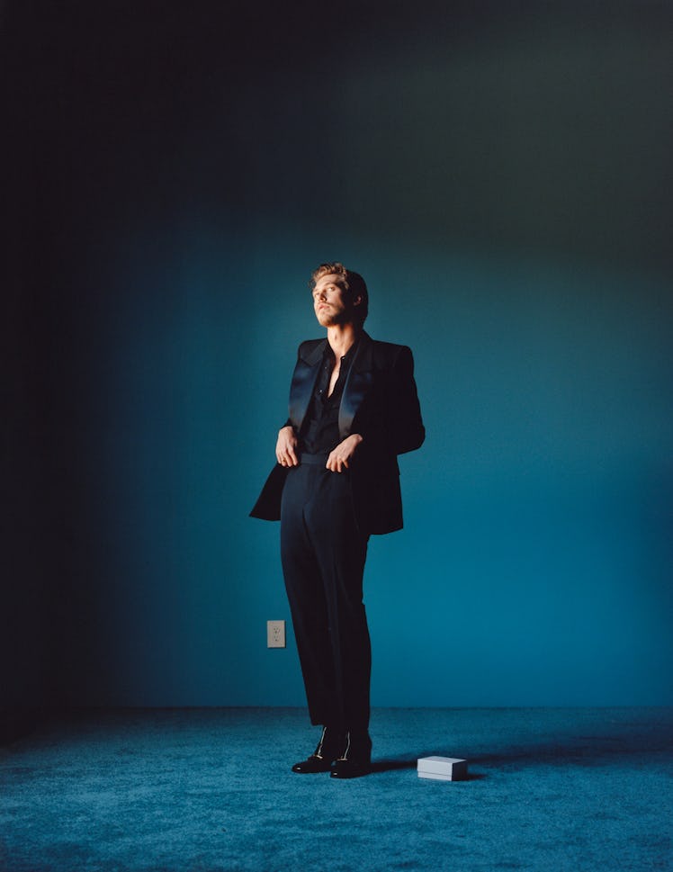Austin Butler wears a black suit, boots and ring.