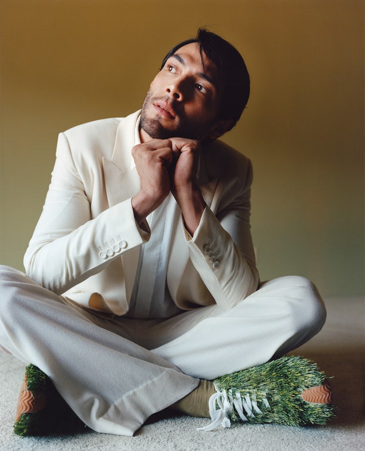 Calva wears a Dior Men jacket, shirt, and pants; Charvet tie; Falke socks; Loewe sneakers.