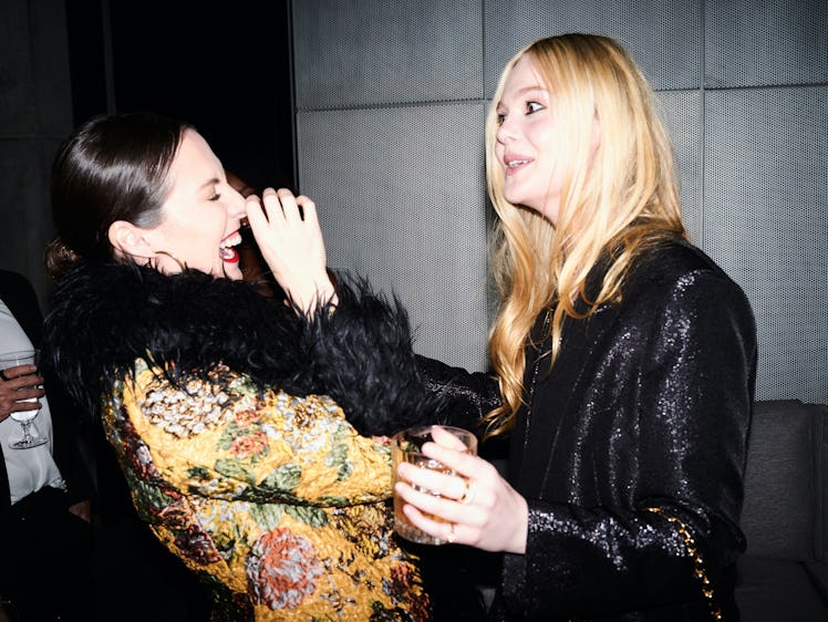 Sara Moonves laughing at a story Elle Fanning is telling her