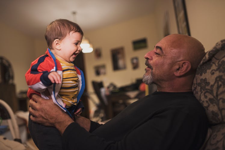 An older dad holding his son.