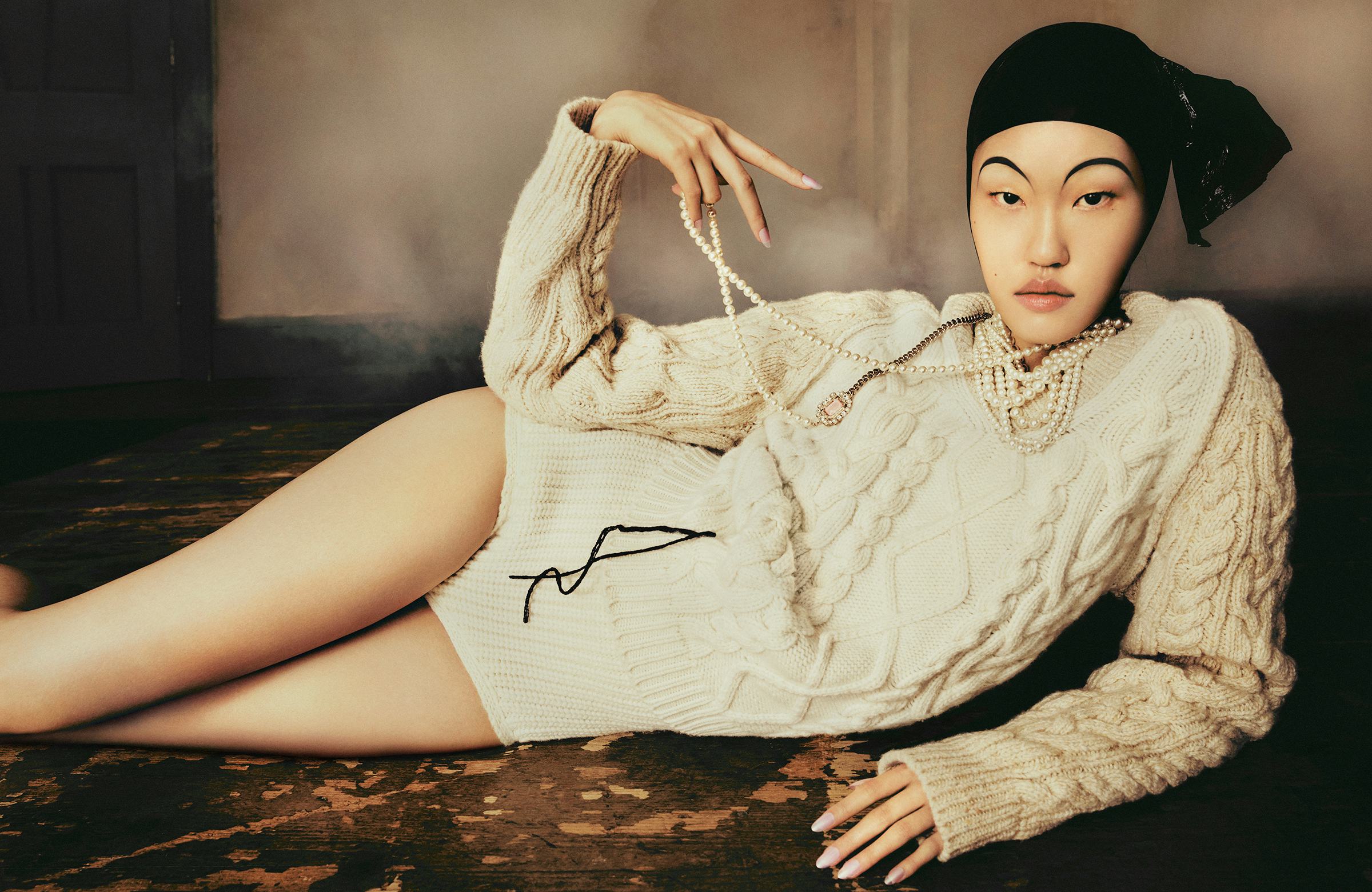 Model Kim wears white knit cable sweater, pearls and sweater shorts