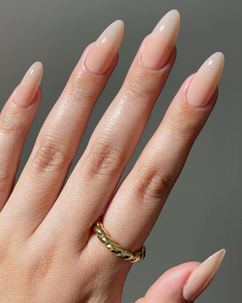 Nude gloss nails are a popular fall nail polish color for 2023.