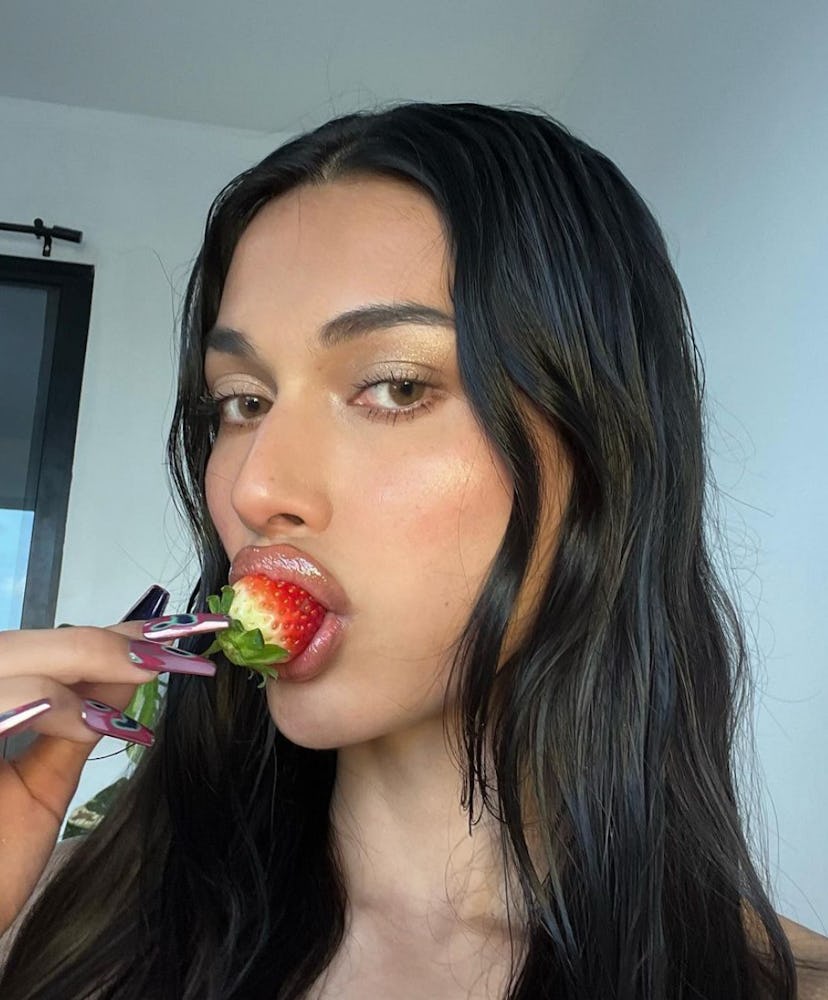 woman bites into strawberry