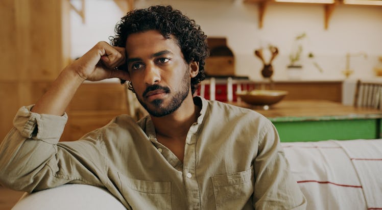 Man sitting on couch looking regretful