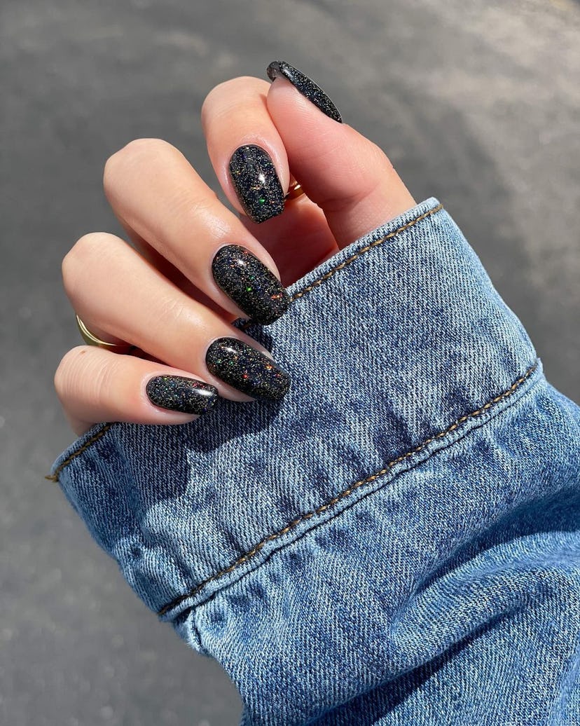 If you need simple manicure inspo, black holographic glitter nails are an easy idea for short tips t...