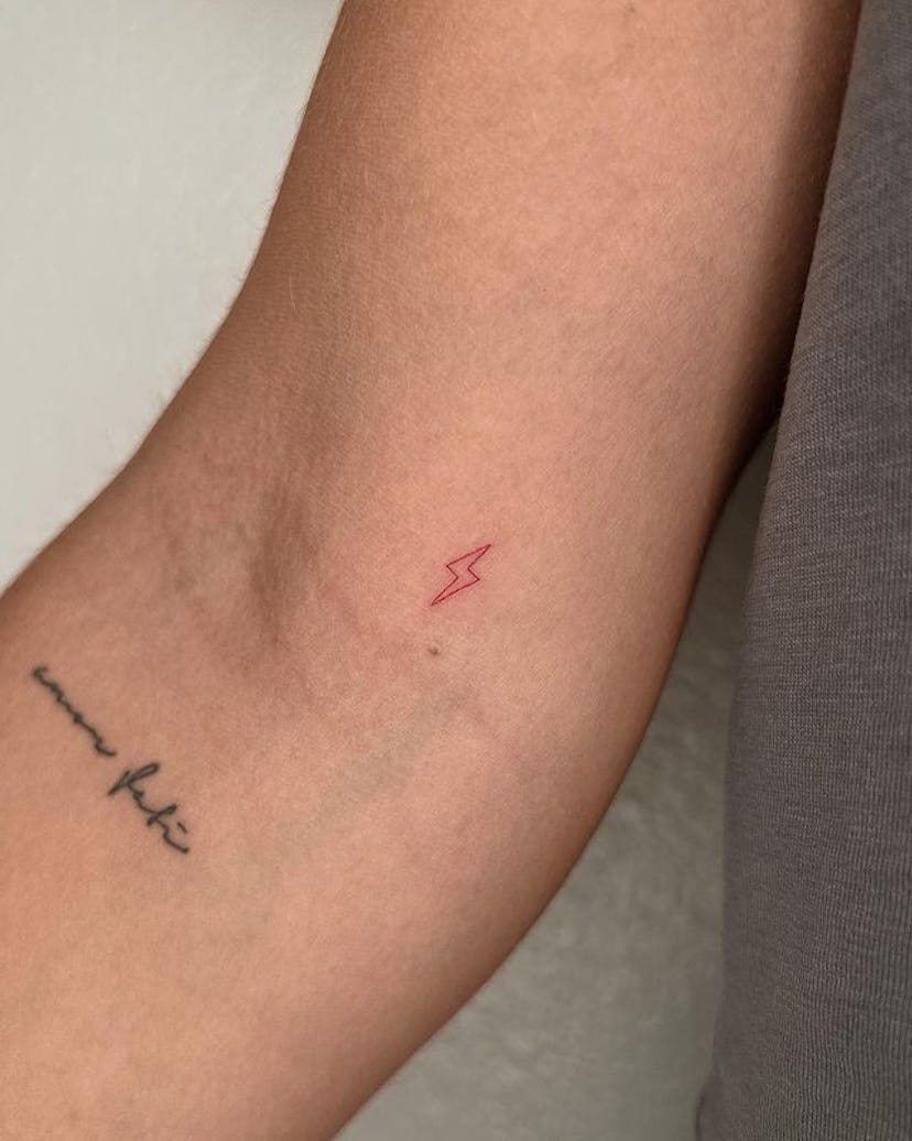 Red ink lightning bolt tattoo.