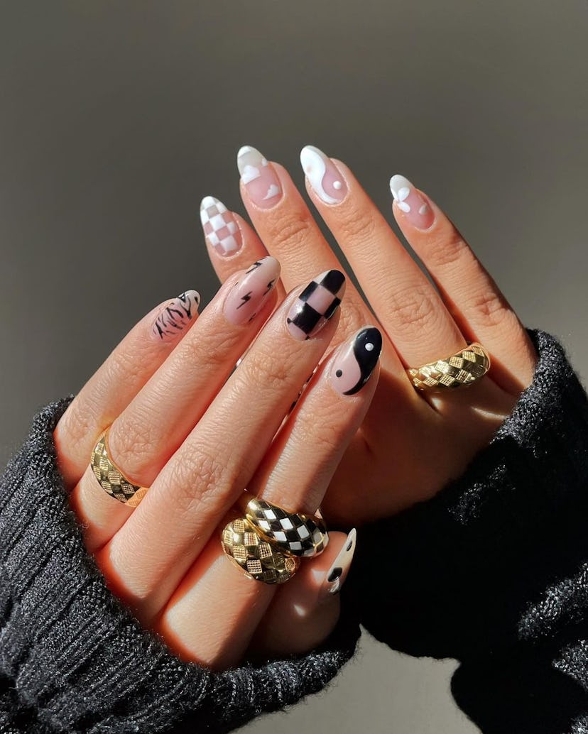 A cute black & white nail art design that combines checkered nails, clouds, and yin yang nail art.