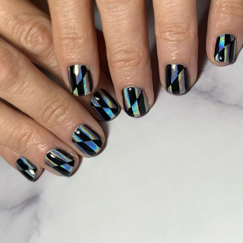 A trendy black & holographic silver checkered nail art design for 2023.