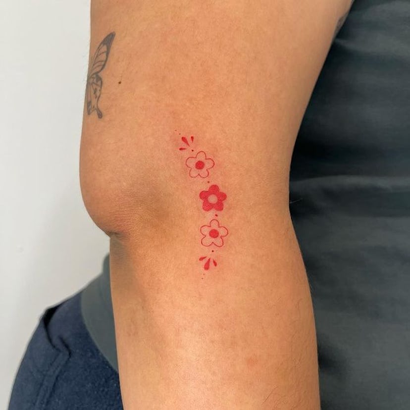 Red ink flower tattoo.