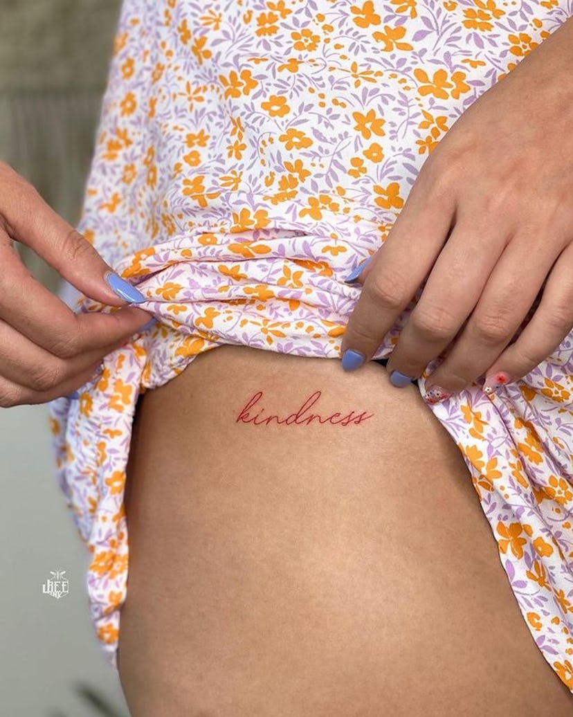 Red ink script tattoo.