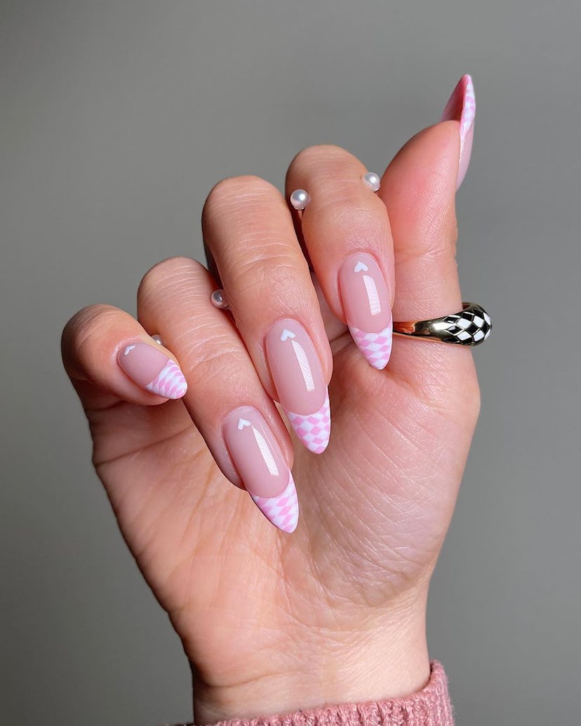 A trendy pink & white nail art design that combines checkered nails and French tips.