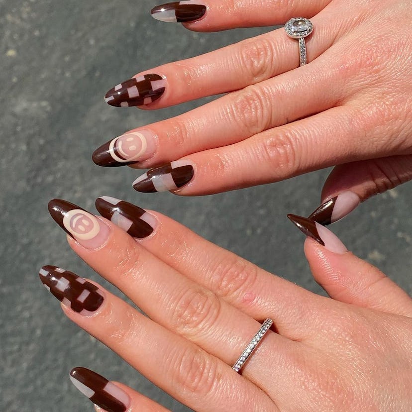 A trendy brown nail art design for 2023 that combines checkered nails and smiley face nail art.
