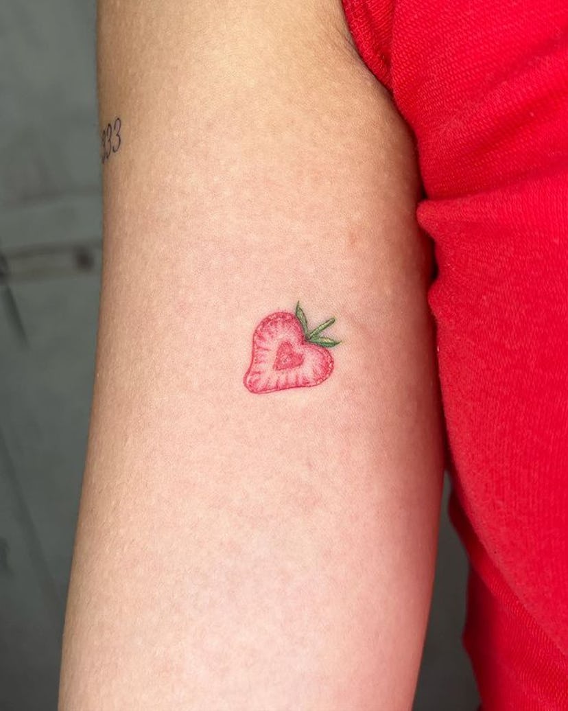 Red ink strawberry tattoo.