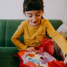 A child unwraps a gift at a birthday celebration.