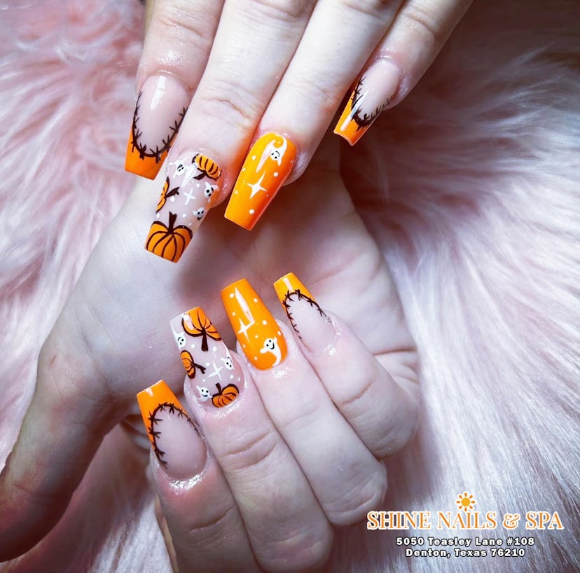 orange square shaped nails with ghost, pumpkin and stitch designs