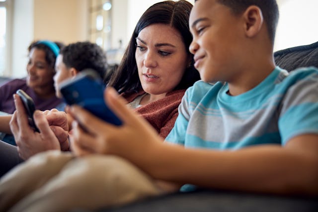 A mom plays on her phone with her kids.