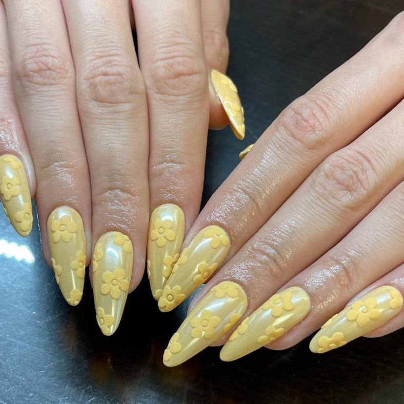 If you need a winter manicure design idea for 2023, these velvety yellow daisy nails are on-trend.