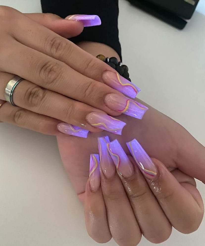 Purple glowing rainbow nails.