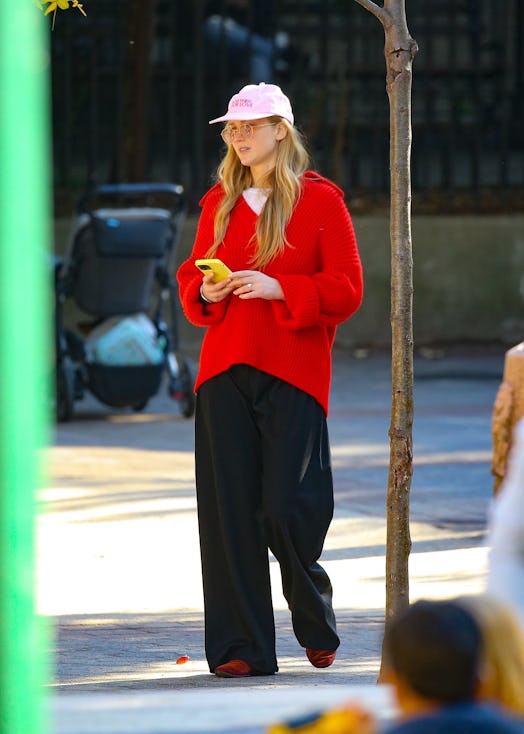 Jennifer Lawrence keeps it casual as she is wearing a red sweater and black pants, along with tinted...