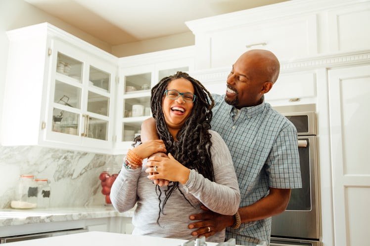 Happy couple in kitchen smiling and hugging