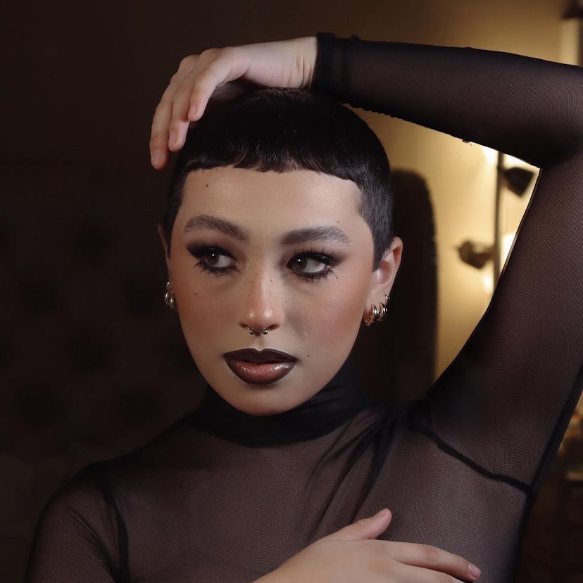 A Wednesday Addams makeup idea for Halloween 2023 with smokey black eyeshadow & dark lip liner.