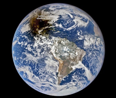 a photo of Earth from space, with a patch of darkness over Texas (labelled "lunar shadow" in white)