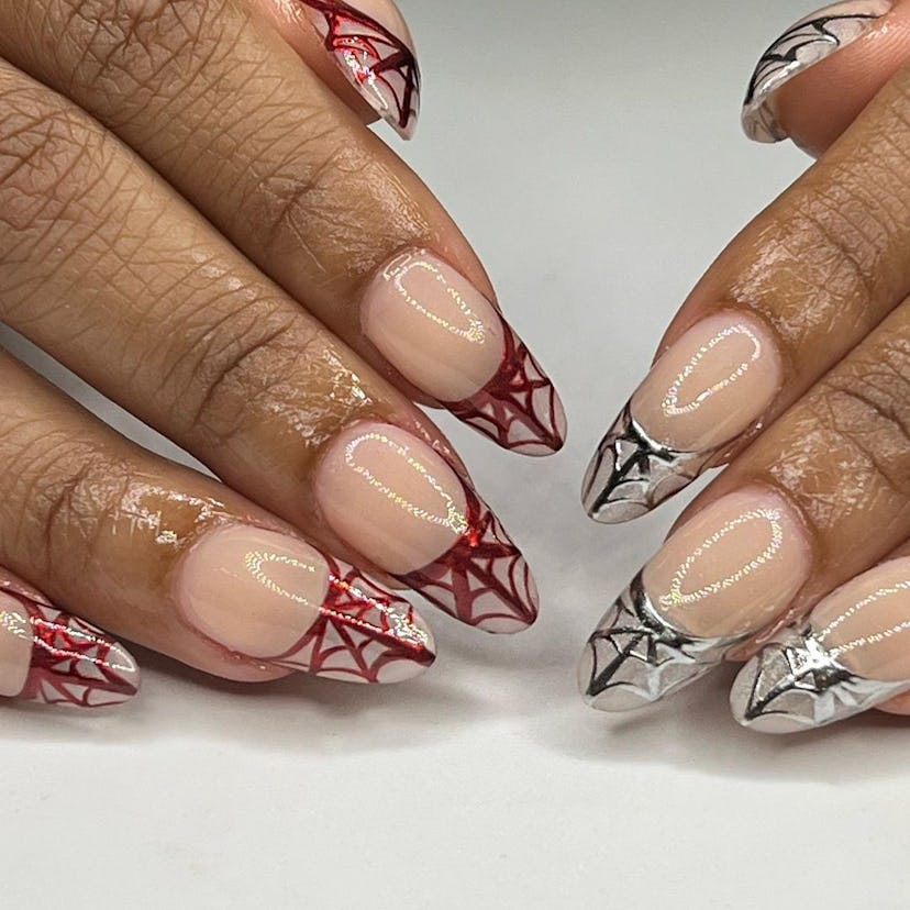 Chrome French tips with spiderwebs are a trendy Halloween nail design for 2023.