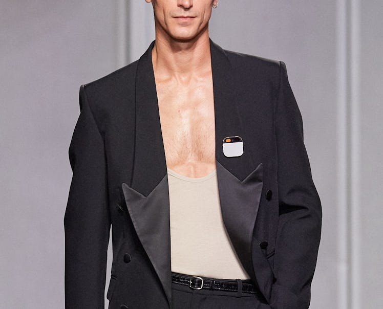 A male model wearing the Humane Ai Pin at the Coperni show during Paris Fashion Week 2023.
