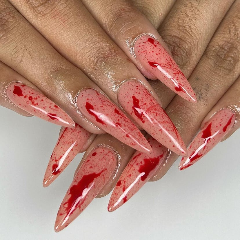 Bloody stiletto nails are a spooky yet cute Halloween nail design for 2023.