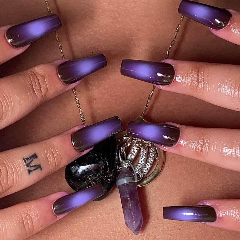 Purple & black aura nails are a trendy Halloween nail design for 2023.
