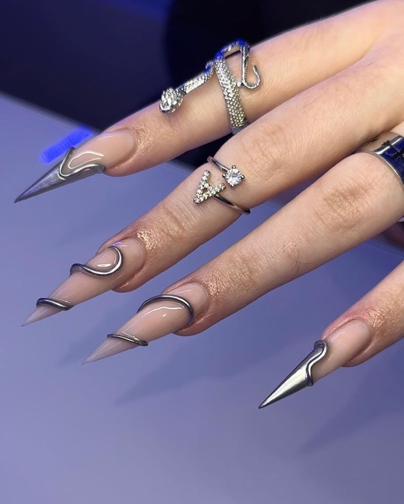 Nude stiletto nails with a 3D chrome nail art design for scorpio season 2023 manicure ideas.