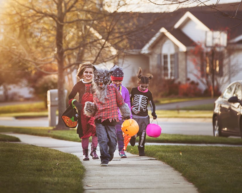 Children in costume trick or treating on Halloween.