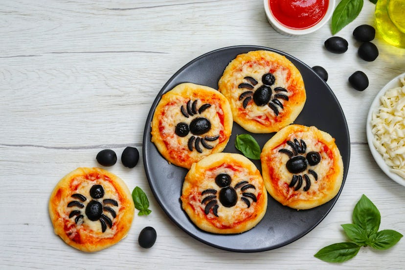 Mini pizzas with olive spiders on top, one of many cute Halloween lunch ideas for kids