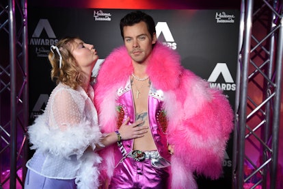 A fan poses for photos as the wax figure of British singer Harry Styles is unveiled at Madame Tussau...