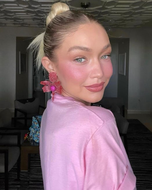 Gigi Hadid's slicked-back Y2K bun, styled by Laura Polko, is a cute & easy hairstyle for greasy hair...