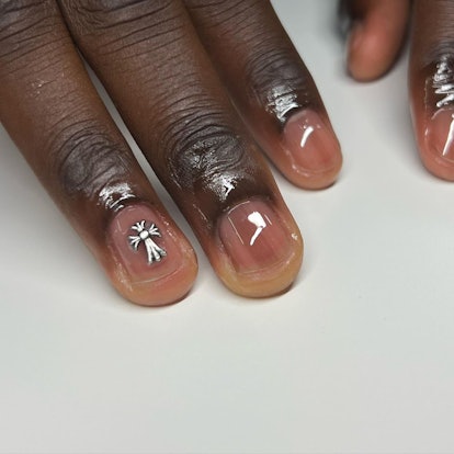 Short clear nails with a silver 3D cross nail design.