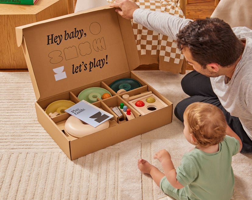 Lifestyle shot of baby and dad opening up Lalo's The Play Box, their new subscription toy box 
