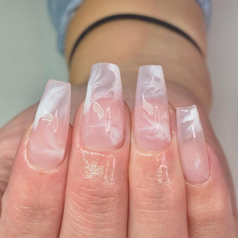 Clear, square-shaped nails with a white marbled nail art design.