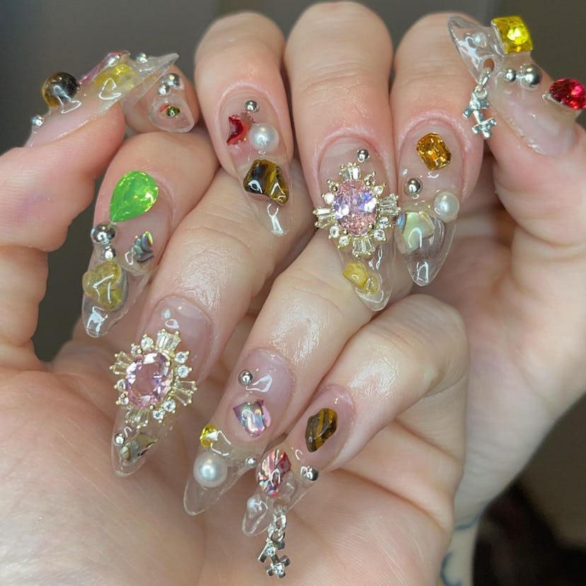 Long clear nails with a 3D nail design.