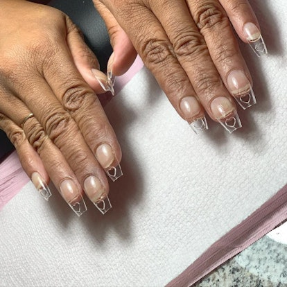 Clear, square-shaped acrylic nails with subtle heart cut-outs on the tips.