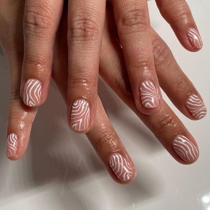 Short clear nails with a simple white abstract design.
