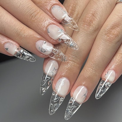 Long clear nails with a silver chrome star nail design.