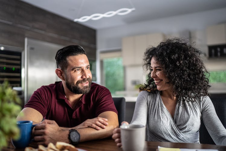 Middle-aged couple smiling and talking in their kitchen