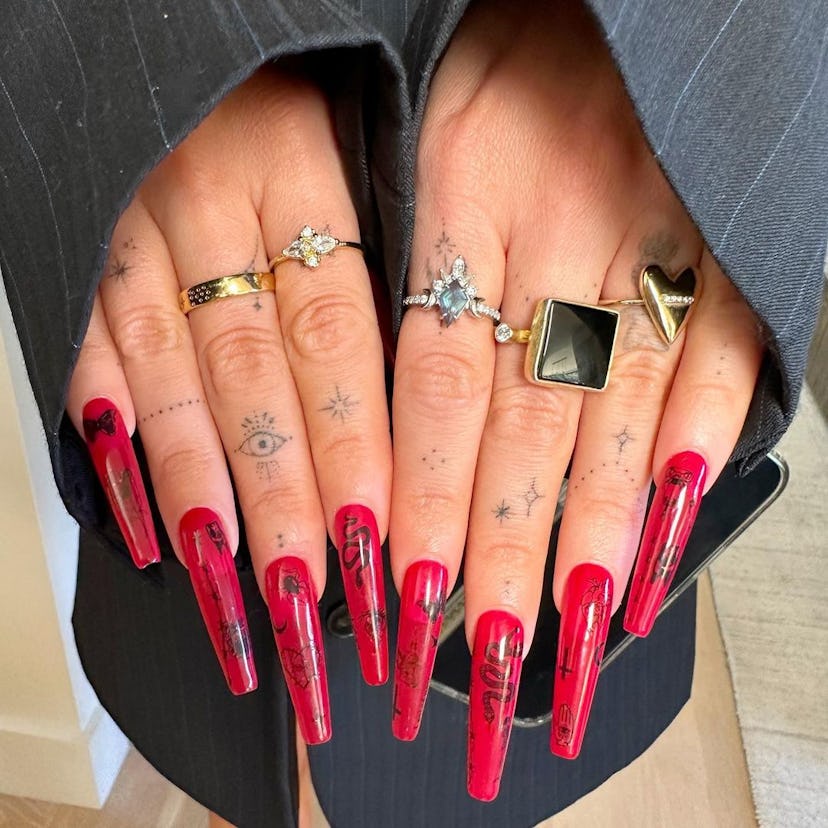 Megan Fox’s long red nails with black Halloween nail art, painted by celebrity manicurist Brittney B…