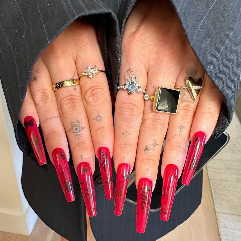 Megan Fox's long red nails with black Halloween nail art, painted by celebrity manicurist Brittney B...