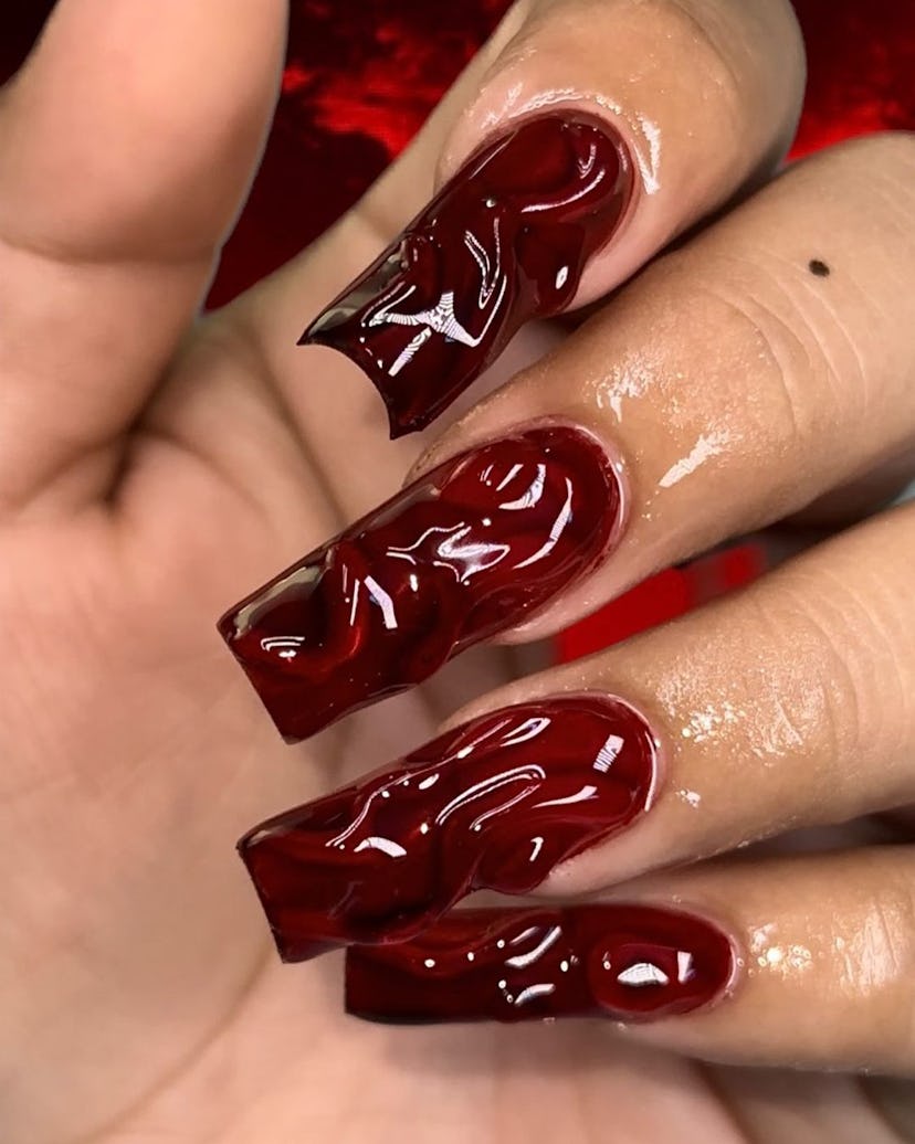 If you need ideas for vampire nails for Halloween 2023, try a trendy red 3D nail design.