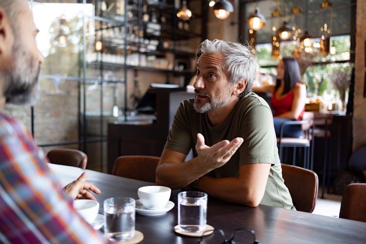 middle aged man venting to his friend at a bar
