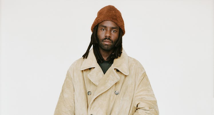 Dev Hynes in trench coat.